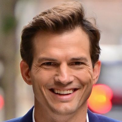 Ashton is posing to the camera smiling.